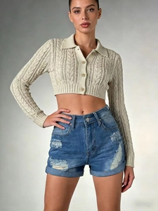 Detail of blue denim shorts with distressed ripped patterns and cuffed hem for women