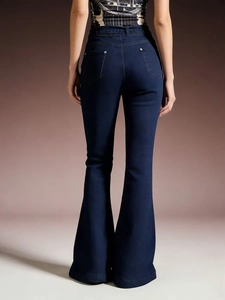 Detail view of high-waisted flared jeans in dark blue with back pockets and slim fit