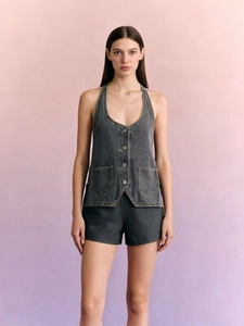 Detail of grey halter denim vest featuring retro wash, metal buttons and symmetry pockets