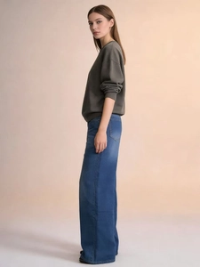 Side view of high-waist loose blue denim jeans with premium wash and elegant drape