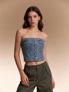 Detail of denim tube top featuring metal buttons, chest pockets, and frayed hemline
