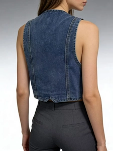 Detail of blue denim vest featuring vertical stitching and irregular V-shaped hem