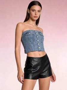 Close-up of denim tube top with metal buttons and frayed hem paired with leather shorts