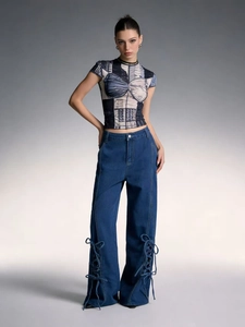 Close-up of the lace-up side design on dark blue high-waist wide-leg denim jeans