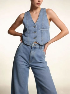 Close-up of light blue denim vest with metal buttons and classic twill texture