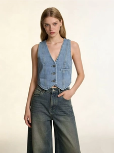 Detail of light blue denim vest with metal buttons and structured slim fit tailoring