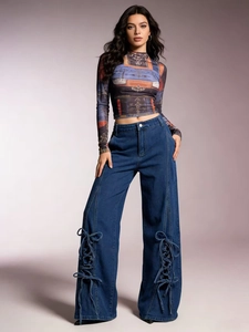 Detail of high-waist wide-leg blue jeans with side lace-up rope tie design on the hem