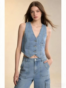 Detail of light blue denim vest showing V-neck and metal buttons for a chic style