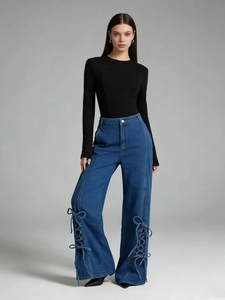Detail shot of vintage wide-leg jeans with unique side lace-up hollow design and blue wash