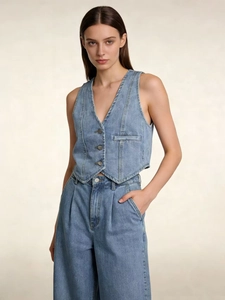 Close-up of three metal buttons and triangle hem on a cropped denim vest for women