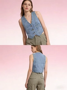 Detail of light blue denim vest showing metal buttons and structure stitching accents