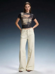 Detail of high-waisted off-white wide-leg jeans with unique horizontal stitching and denim texture