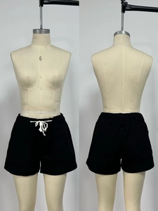 Detail view of black casual shorts featuring elastic waistband and contrast drawstrings
