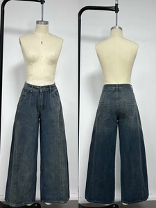 Dettaglio dei jeans a vita alta a gamba larga con lavaggio vintage e cucitura verticale