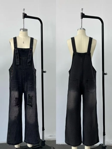 Vista frontale e posteriore della salopette in denim nero lavato con strappi e gamba larga