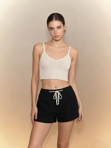 Detail of knit crop top and black drawstring shorts set on a fashion model