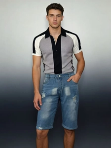 Close-up of men's distressed denim shorts with ripped details and rolled hems