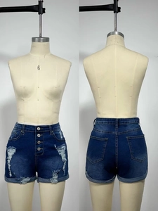 Détail de short en jean taille haute avec quatre boutons métalliques et effets déchirés usés