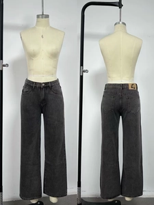 Close-up detail of dark grey high-waisted wide-leg jeans with a cherry logo leather patch
