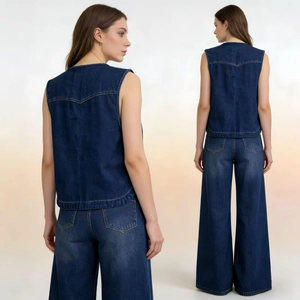 Dettaglio delle cuciture a V sulla schiena e dell'orlo curvo sul gilet in denim blu scuro