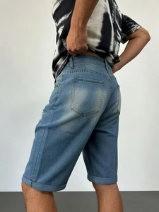 Detail of men's light blue denim shorts featuring cuffed hems and distressed pocket details