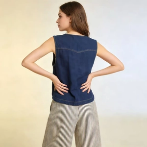 Dettaglio del retro di un gilet in denim blu scuro senza maniche con cuciture a vista
