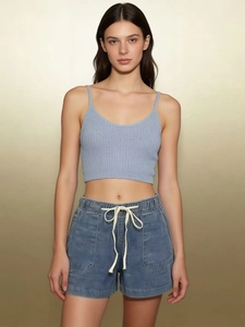 Detail view of denim shorts featuring elastic drawstring waist and large front pockets