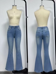 Detail view of light blue high-waisted flare jeans with washed effect and slim fit design