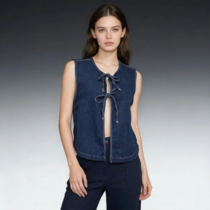 Dettaglio di un gilet di jeans blu scuro con eleganti chiusure a fiocco sul davanti