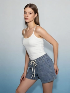 Detail of blue denim shorts with elastic drawstring waist and large front pockets