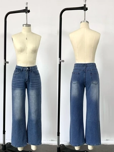 Detail of high waisted straight leg jeans featuring vintage wash and cat whisker textures