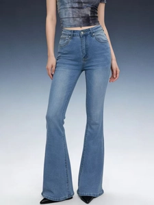 Detail of light blue high-waisted flared jeans with a slim fit and retro washed denim finish