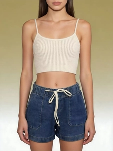 Close-up of high-waist denim shorts with white drawstring and rib-knit crop top