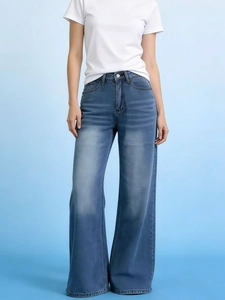 Detail showing high-waisted light blue wide-leg jeans with natural faded finish texture