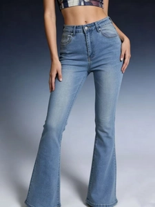 Detail of high-waisted flare jeans featuring washed denim fabric and traditional pockets