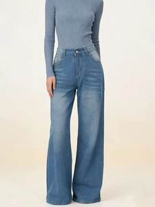 Detail of high waisted wide leg jeans with natural whiskering and light blue wash finish