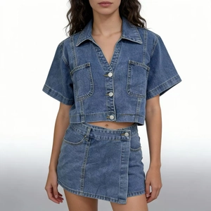 Dettaglio completo di un set denim blu scuro con giacca corta e gonna pantalone chic