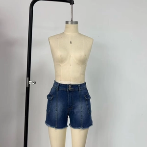 Detail of high waist denim shorts with cargo pockets, metal buttons and frayed edges