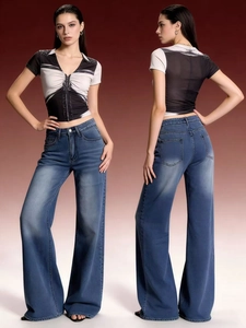 Detail of high waist wide leg blue jeans paired with a slim fit printed t-shirt