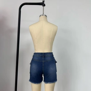 Detail of dark blue denim shorts featuring frayed edges and side cargo pocket on a model