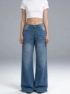 Detailed macro view of high-waisted wide-leg jeans with vintage cat-whisker wash detail