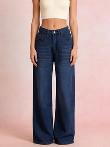 Detail of high-waisted wide-leg jeans in dark blue with retro faded whisker patterns
