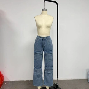 Detail view of washed blue straight-leg cargo jeans showing layered flap pockets and denim texture