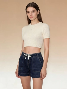 Close-up of high-waist drawstring denim shorts paired with a white knit crop top