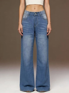 Detail view of high-waisted blue wide-leg jeans with vintage whiskering and faded finish