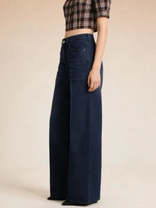 Detail view of high waist dark blue wide leg denim pants with elegant draped silhouette
