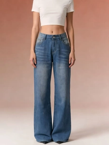 Detail of high-waisted light blue washed wide-leg jeans with vintage finish and side pockets