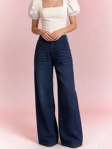 Detail of high waisted wide leg denim jeans in dark blue with a clean straight cut finish