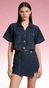 Dettaglio di un set in denim blu scuro con cuciture a contrasto e bottoni in metallo