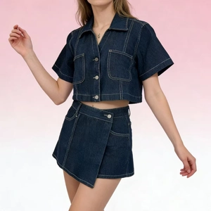 Dettaglio di un set in denim blu scuro con cuciture a contrasto e bottoni in argento